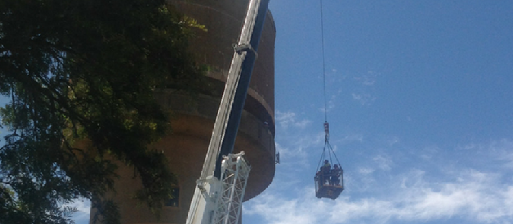 Crane lifting an installation crew to install a new antenna