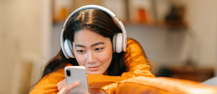 Young woman with headphones looking at her phone
