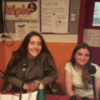 Two young female excchange students sitting in the Triple t studios in front of two microphones