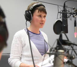Woman with short brown hair with headphones on in the studio